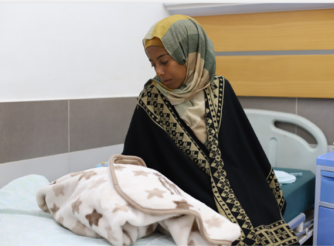 Umm Fulan, a new mother who has just given birth at Al-Awda Hospital. 